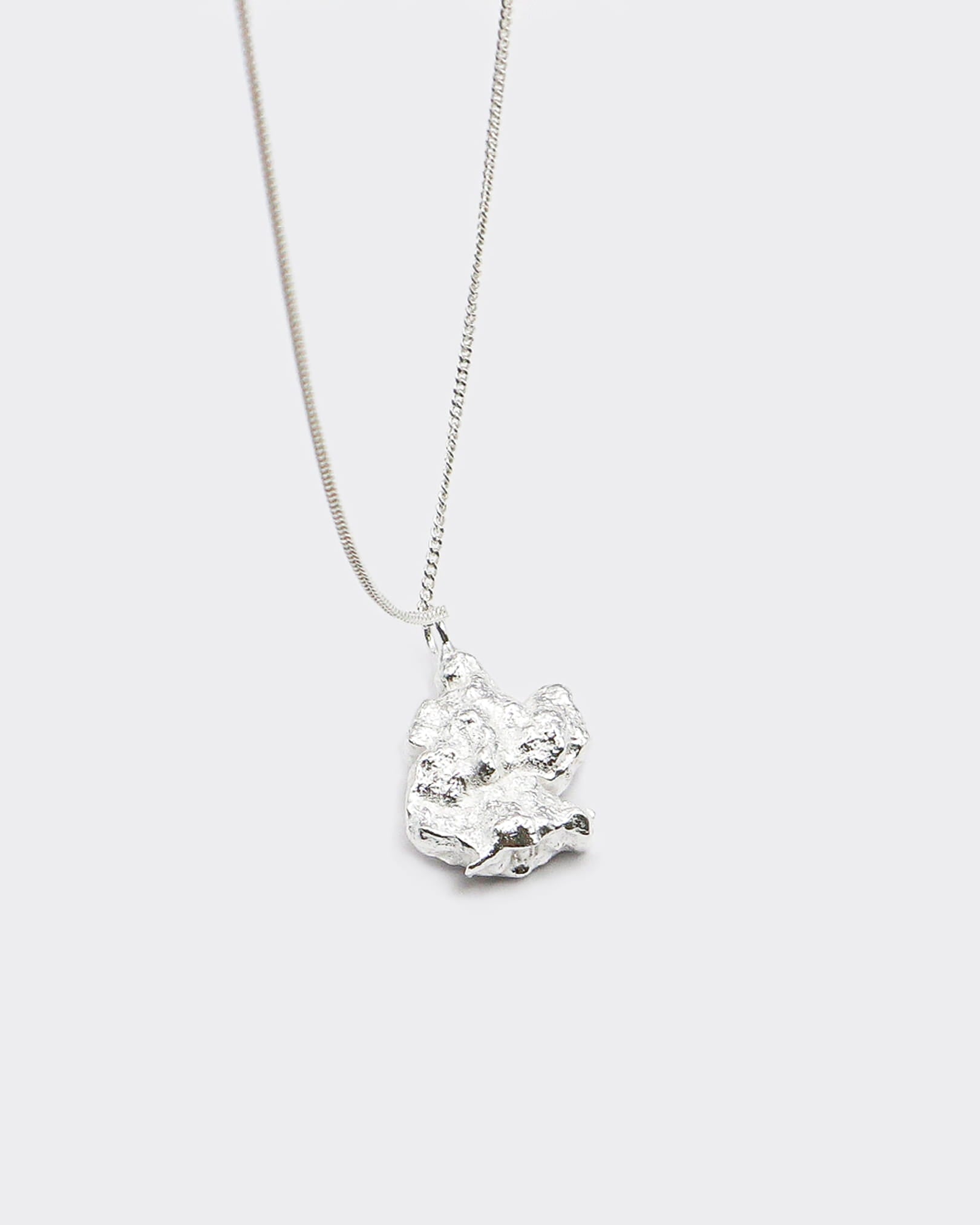 Atelier Domingo's Brooklyn necklace recalls a gold nugget. The pendant is made of a high-quality 925 Sterling silver plating (10 microns). The cuban chain is made of solid 925 sterling silver. This necklace is unisex, made in Spain for both men and women.