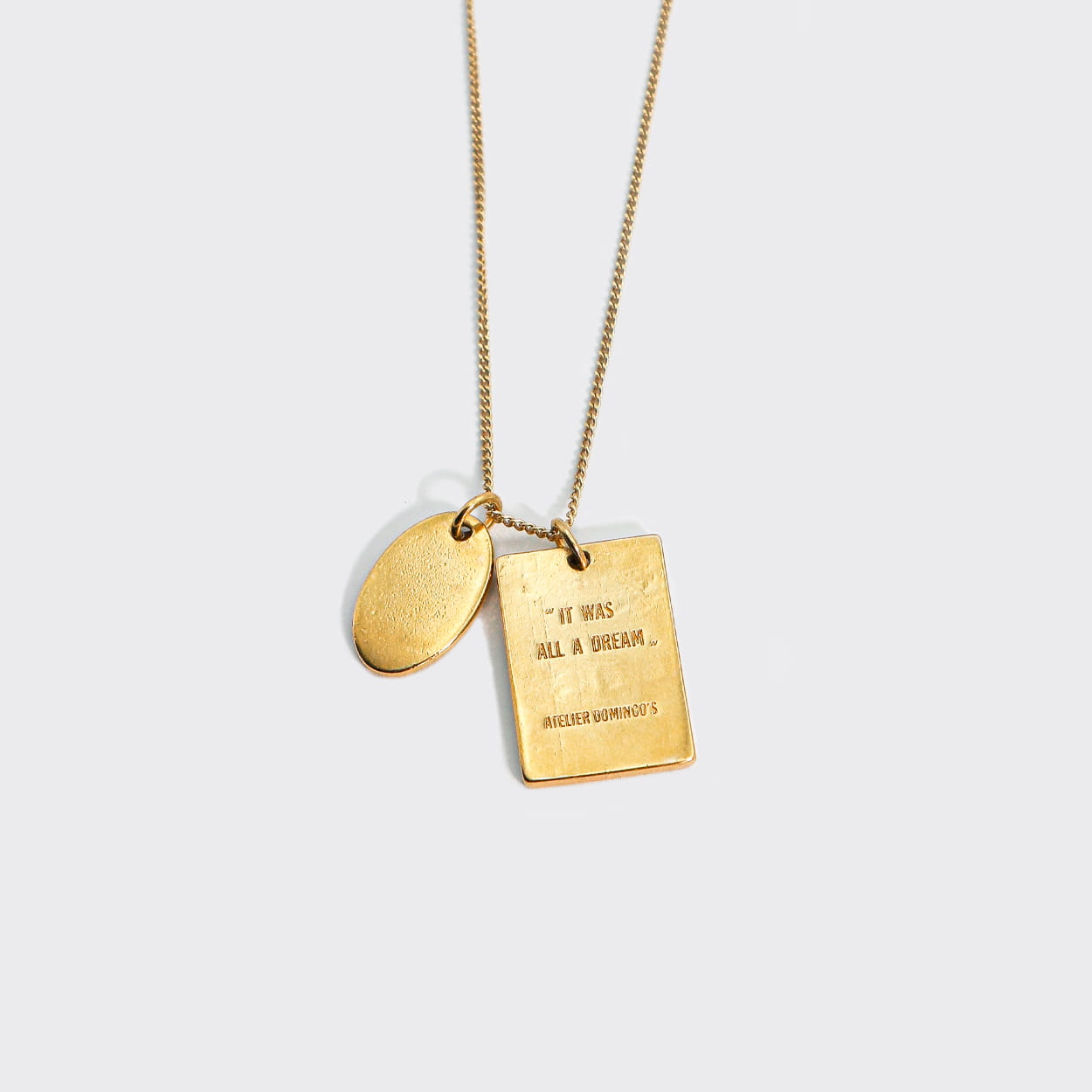 Atelier Domingo's L'Amour necklace is made in Spain. This jewelry is unisex. It is for both men and women. The pendant is made of a high-quality 24 karat gold plating. The cuban chain is made of solid 925 Sterling silver with a high-quality 18 karat gold plating.