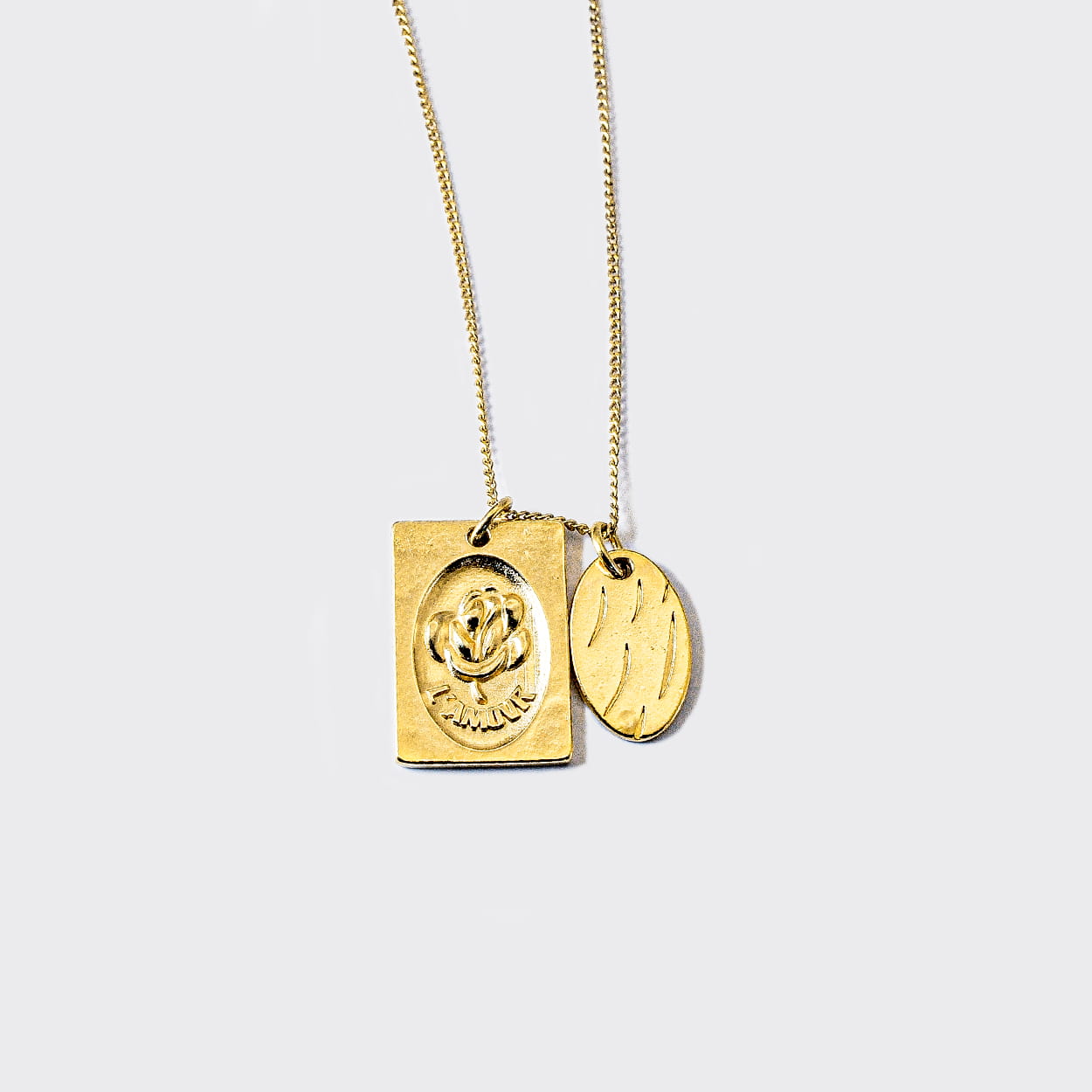 Atelier Domingo's L'Amour necklace is made in Spain. This jewelry is unisex. It is for both men and women. The pendant is made of a high-quality 24 karat gold plating. The cuban chain is made of solid 925 Sterling silver with a high-quality 18 karat gold plating.