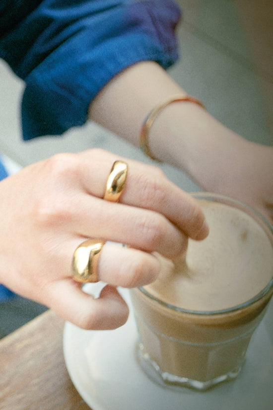 Andrea is wearing our gold Block and Classic rings. Those two rings are made of a high-quality 24 karat gold plating.