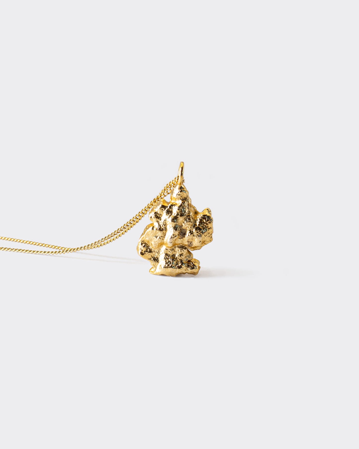 Atelier Domingo's Brooklyn necklace recalls a gold nugget. The pendant is made of a high-quality 24 karat gold plating. The cuban chain is made of 925 sterling silver with a high quality 18 karat gold plating. This necklace is unisex, made in Spain for both men and women.