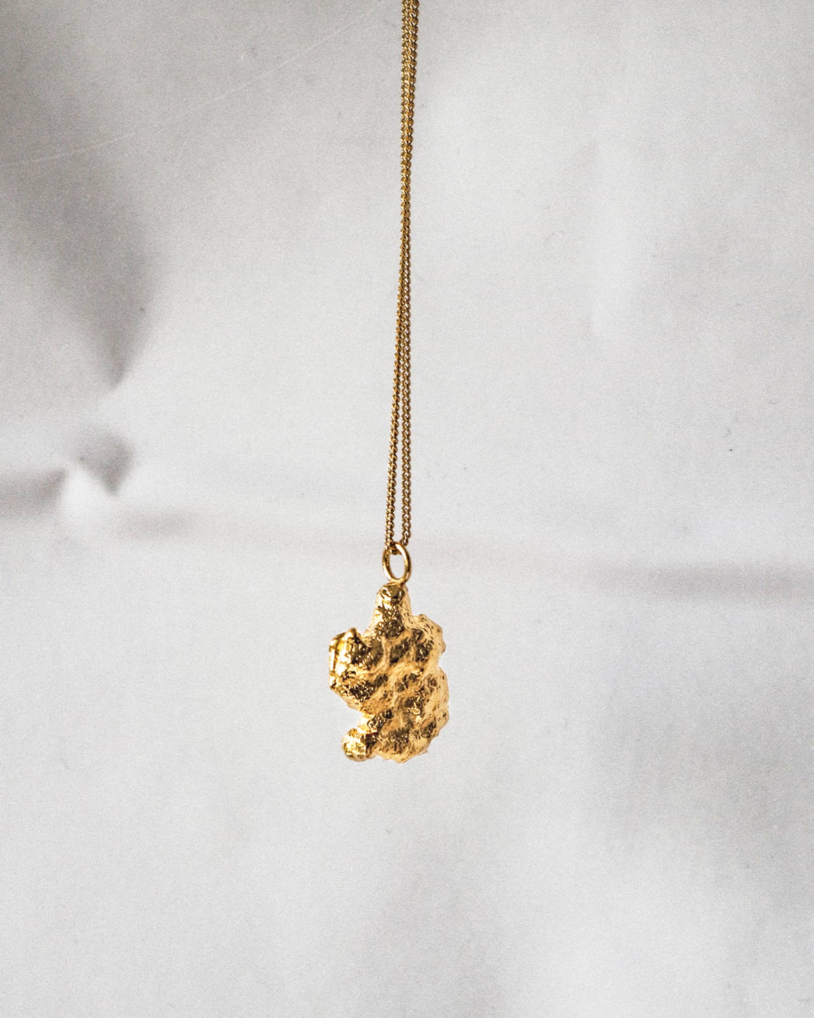 Atelier Domingo's Brooklyn necklace recalls a gold nugget. The pendant is made of a high-quality 24 karat gold plating. The cuban chain is made of 925 sterling silver with a high quality 18 karat gold plating. This necklace is unisex, made in Spain for both men and women.