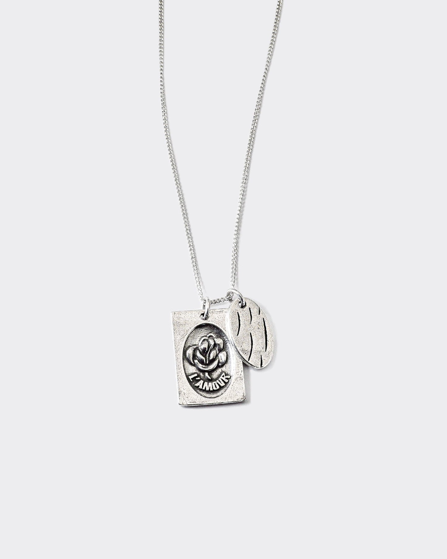 Atelier Domingo's L'Amour silver necklace is made in Spain. It is a unisex jewelry, made for both men and women. The pendant is made of a high-quality 925 Sterling silver plating (10 microns). The cuban chain is made of solid 925 Sterling silver.