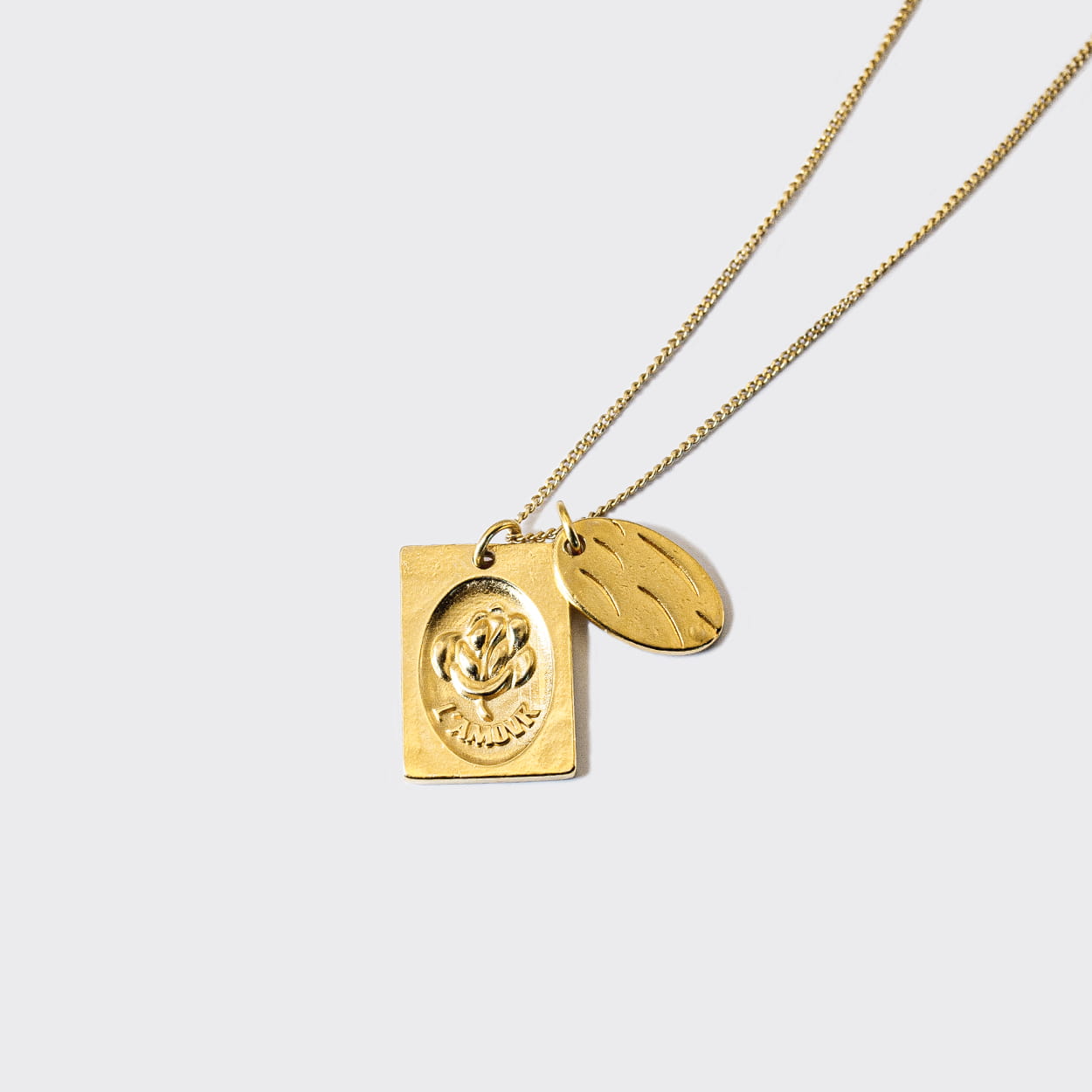 Atelier Domingo's L'Amour necklace is made in Spain. This jewelry is unisex. It is for both men and women.  The pendant is made of a high-quality 24 karat gold plating. The cuban chain is made of solid 925 Sterling silver with a high-quality 18 karat gold plating.